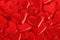 Red shiny fabric hearts arranged randomly. Background