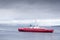 Red ship ferry transport over sea under dark storm clouds