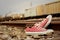 Red shoes leaning on the train tracks.