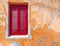 Red shutters window on colorful ocher wall in Anafiotika picturesque neighborhood under acropolis, space for text