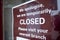 Red sign on the door of a small shop  stating that it is closed during the national lockdown during the covid pandemic in the