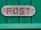 Red sign of an old vintage mail letter box post on green wood