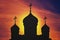 Red silhouette of an Orthodox church with crosses on the domes. sunrise at the religious building