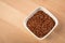 Red skinned raw Jasmine rice in porcelain bowl on wooden background