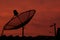Red sky at night and dish satellite on the roof