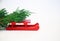Red sled delivering christmas tree with on white background.