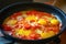 Red sliced â€‹â€‹tomatoes fried in a pan for cooking scrambled eggs