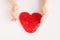 Red slime in heart shape in kid hands. Kid hands playing slime toy on white background. Love and valentines day concept