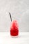 Red Slushie - drink with cherry. Sweet shaved ice or Spanish granizado in tall glass with drinking straw. Refreshing summer drink