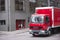 Red small box semi truck for delivery on city streets