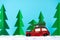 Red small car in the snow with cartoon paper trees background.