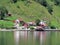 red small houses Norwegian village, fjord background