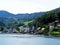 Red small houses Norwegian village, fjord background