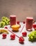 Red smoothie drink in glass with straw and fruits berries ingredients on white wooden background, top view strawberries, whit