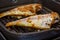 Red snapper fish marinated with spice mix being grilled in a pan