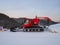 Red snow groomers clean the slope of the mountain in the mountain ski resort of Gornaya Salanga