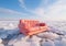 Red sofa over icy landscape. Winter atmosphere style, surreal. AI generative