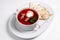 Red soup in a white plate. Borsch with bread appetizer