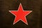 Red Soviet star on a dark green protective camouflage background