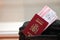 Red Spanish passport of European Union with airline tickets on touristic backpack