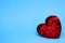 Red sparkling heart with sequins on a blue background. Valentine's Day concept. The idea of love.