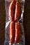 Red spicy spanish mediterranean chorizo sausages in plactic vacuum packed wooden table background