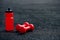 Red sports water bottle and sports dumbbells on a black rubberized sports field in the background light, background image