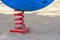 a red spring part the child fun play park toy located strongly with sand ground.