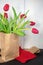 Red spring tulips in brown paper sack