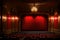 red stage closed curtain with spotlight, theater with red chairs, empty theater gold interior design