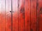 Red stained  house wall fence wood boards siding fresh paint maroon stain shiny cabin