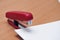 Red stapler fastens white paper
