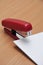 Red stapler fastens white paper