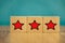 Red stars on wooden cubes on a blue background. Stars mean assessing quality. five-point rating system