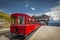 Red steam rack cogwheel train waiting in the Schafbergspitze station on the peak of Schafberg mountain peak in Austrian