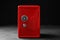 Red steel safe with mechanical combination lock against background
