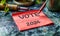 Red sticky note with VOTE 2024 text isolated on a light background, symbolizing political engagement, election campaigns, and