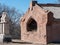 A red stone mausoleum in a cemetery