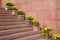 Red stone staircase with flowers in flowerpots