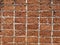 Red stone wall stacked up grout with grey cement Rock porous rough surface material texture background