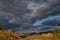 Red stones bay of lake baikal with yellow dry grass in autumn. Blue water with islands, clouds Sunset light.