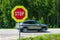 Red stop road sign in the foreground and blurred fast car in the background