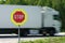 Red stop road sign in the foreground and blurred fast truck in the background