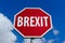 Red Stop Sign with text Brexit against blue sky
