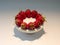 Red strawberries on white round plate studio shot