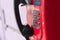 Red street payphone with round stainless steel buttons close-up.