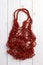 Red string shopping bag, or net bag, or mesh bag.