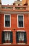 Red stucco house with old green shutter windows in Monaco