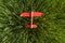 Red styrofoam plane is on grass