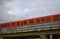 Red subway cars on a overpass